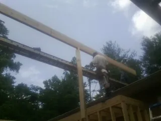 Carpenter setting a ridge beam over a new addition frame — Ice Dam Removal by Roofing Brothers in Cochranton