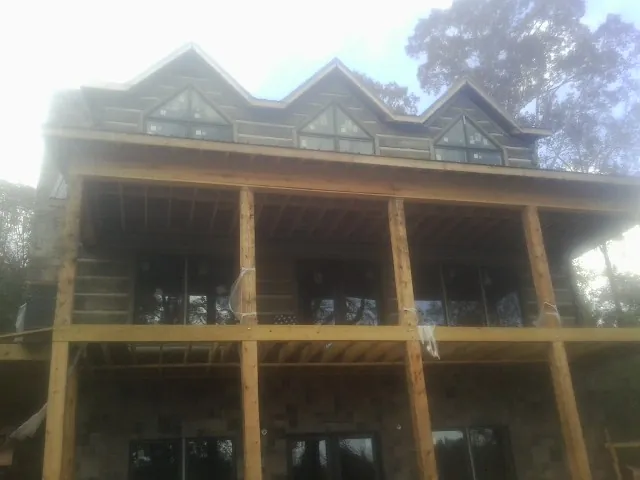 Dormers and porch framing on a large log home under construction — Roof Coating work by our crew in Cochranton